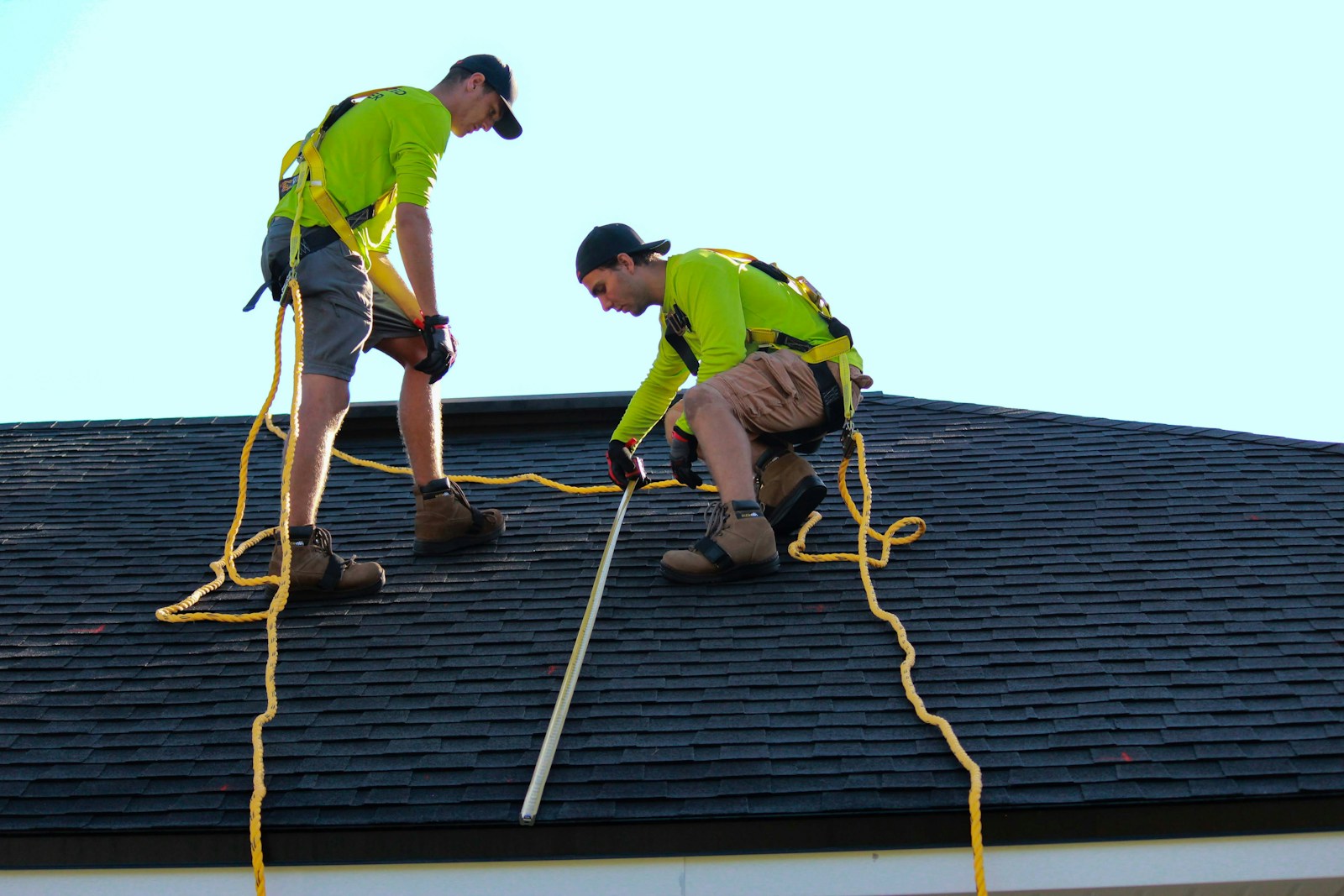 a couple of people that are on a roof performing roof maintenance