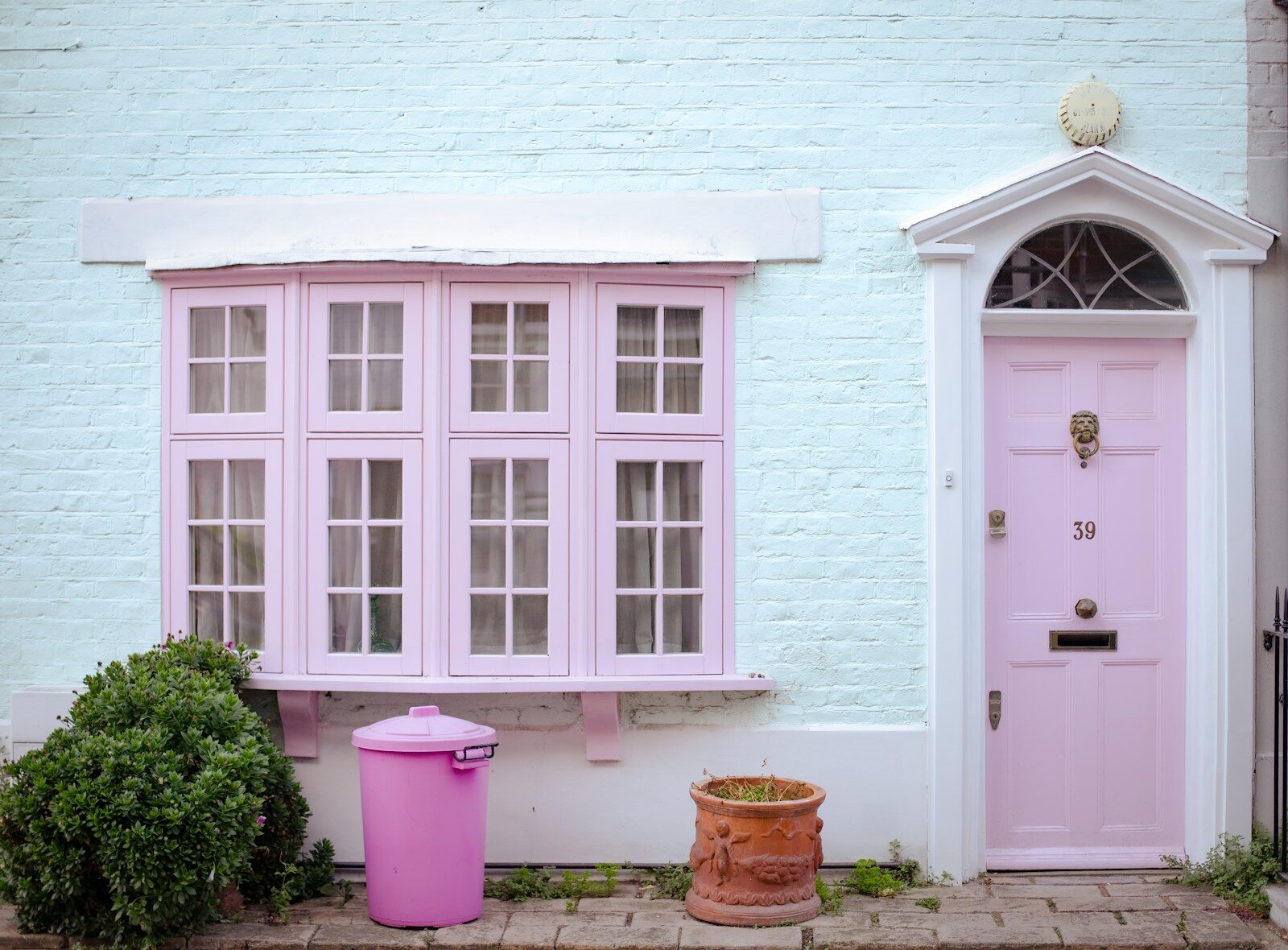 Pastel pink door and bay window on house